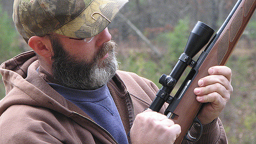 a man cocking his gun accessorized with the one of the best shotgun scopes