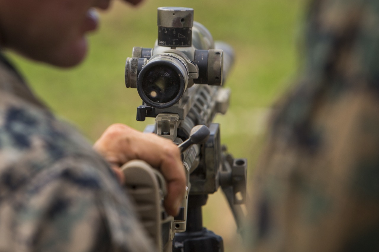 photo focusing on rifle scope attached to the firearm