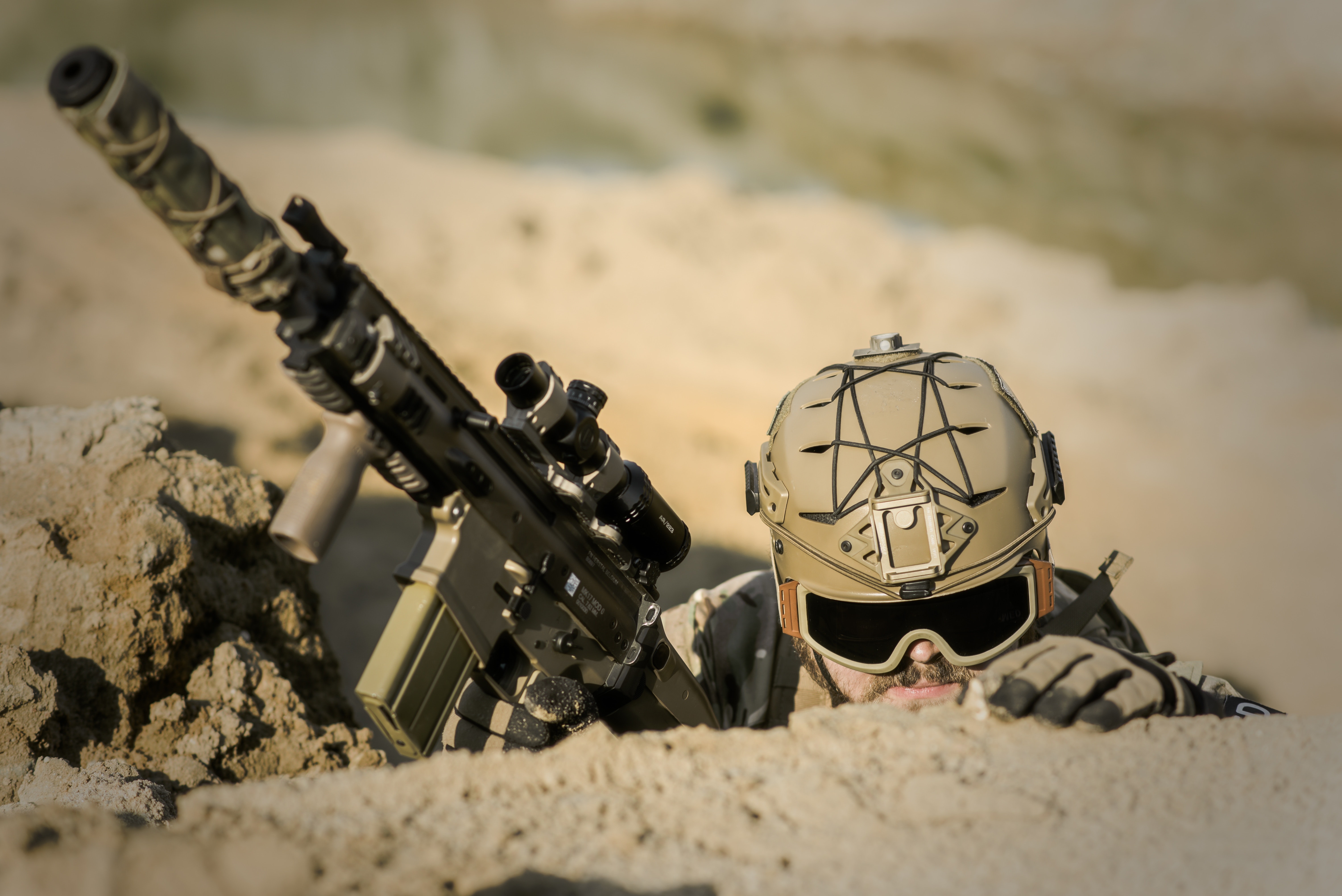 a soldier hiding and holding up a firearm with scope