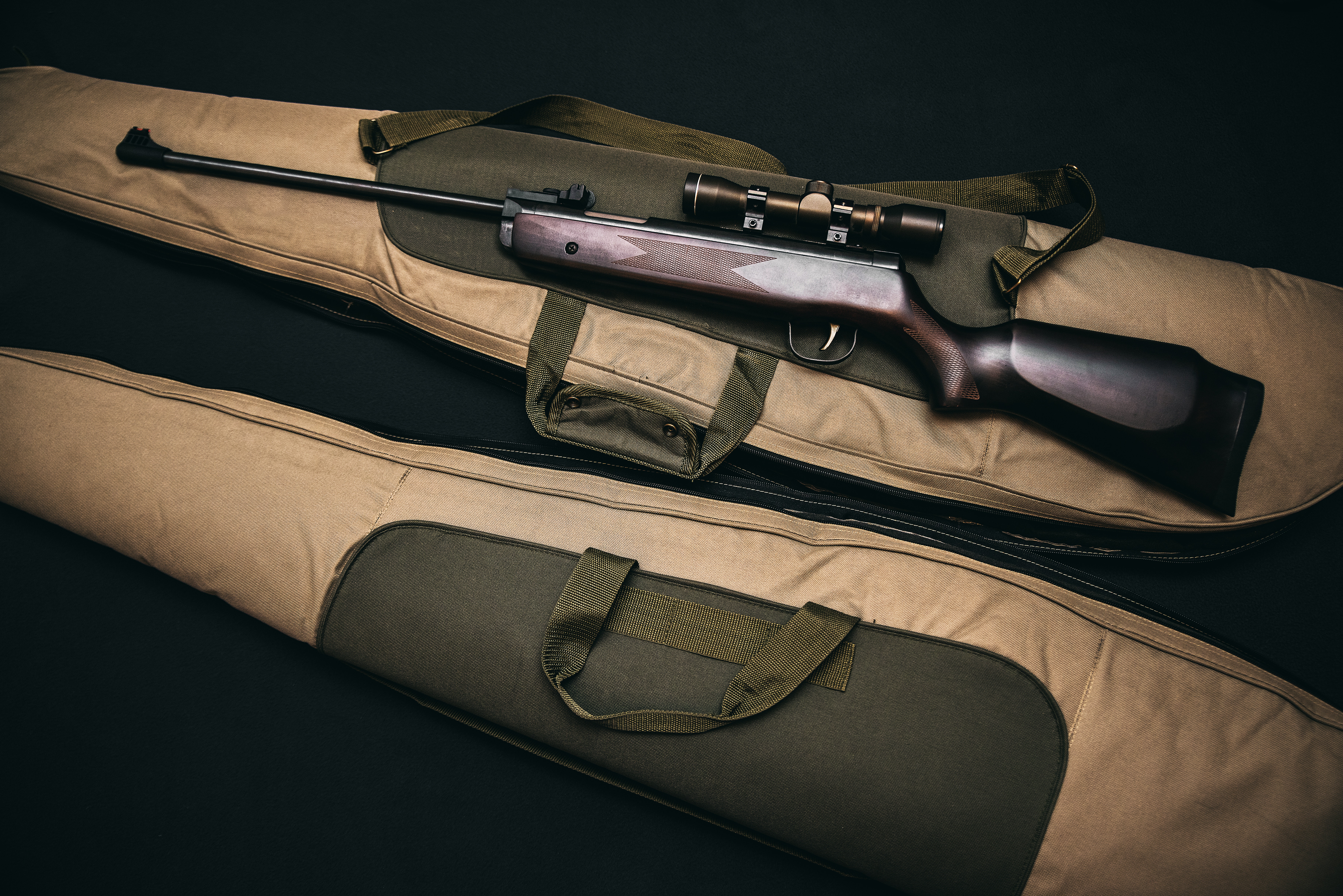 a rifle with scope on top of a rifle bag