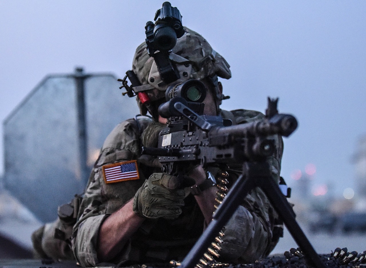a soldier looking through the scope attached to the firearm