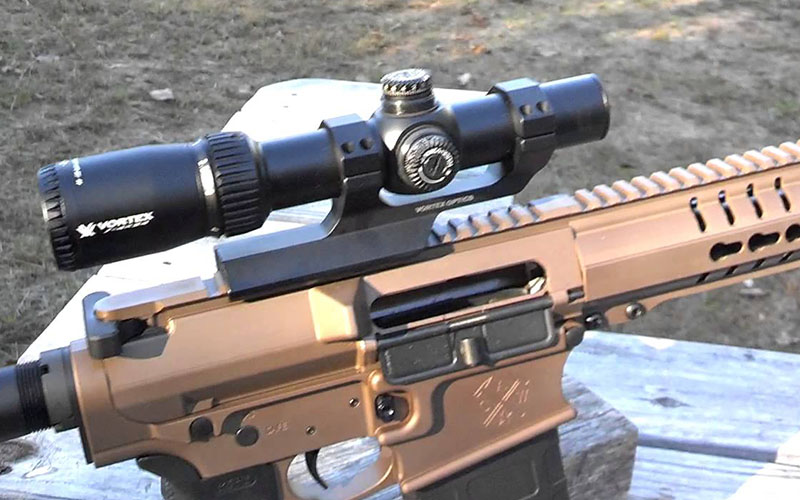 close-up photo of a 4x scope attached to a firearm