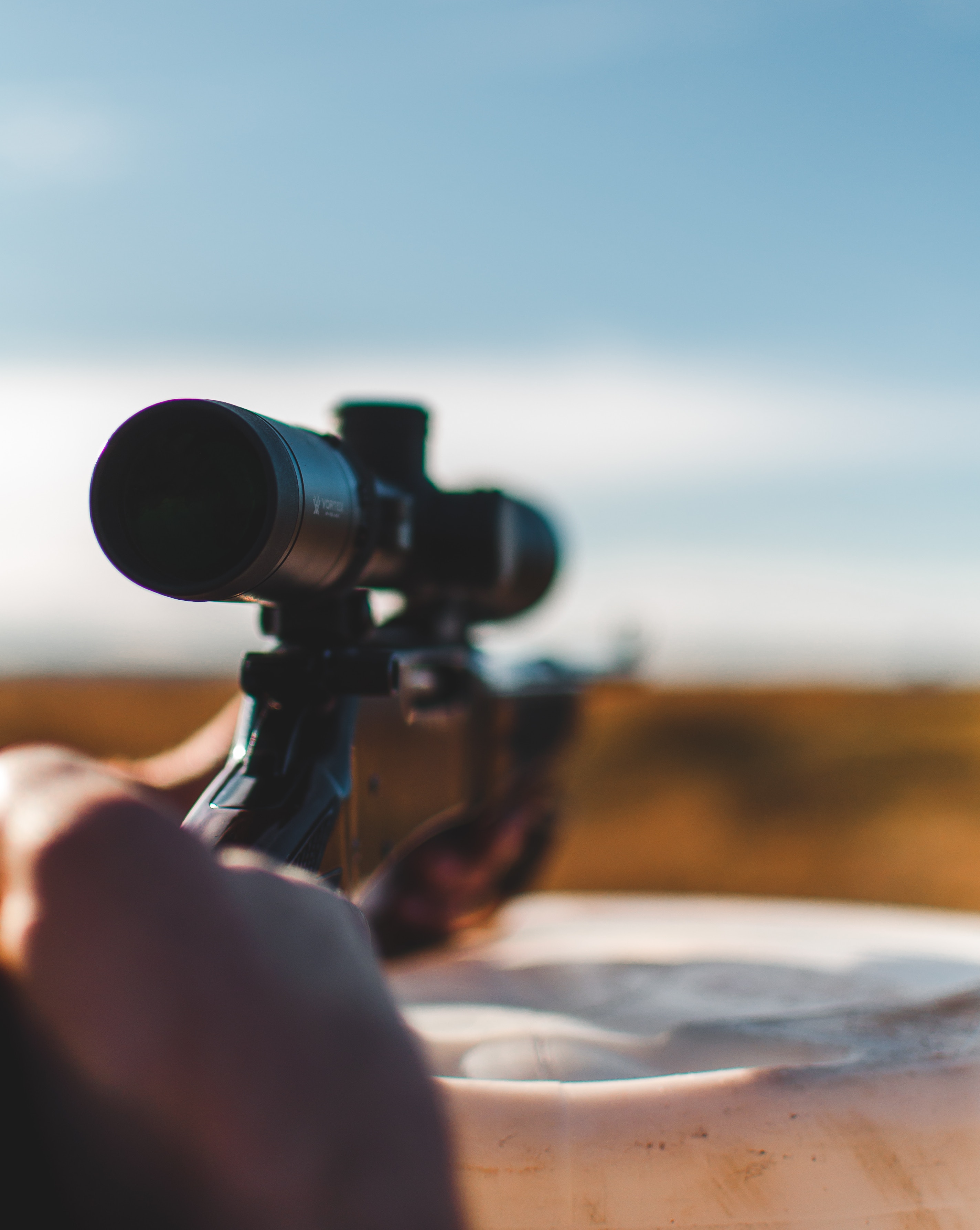 close-up photo focused on a 4x scope attached to a firearm being used during hunting activity