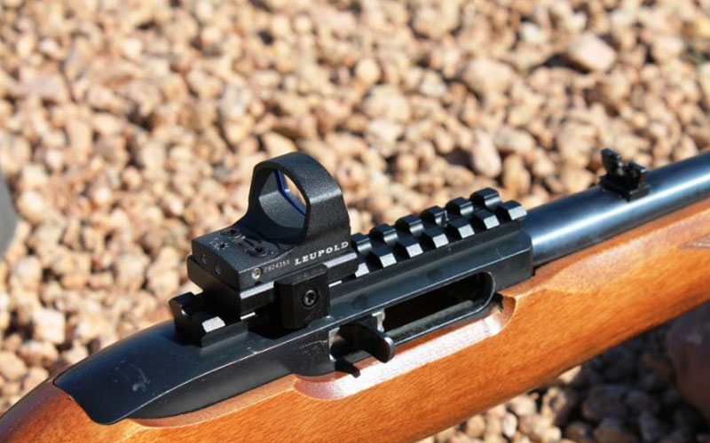 close-up photo focused on a simple sight scope attached to a firearm