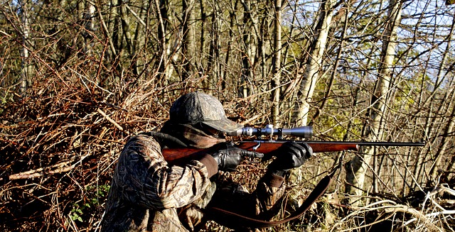 a man aiming to shoot by using a rifle with a rimfire scope