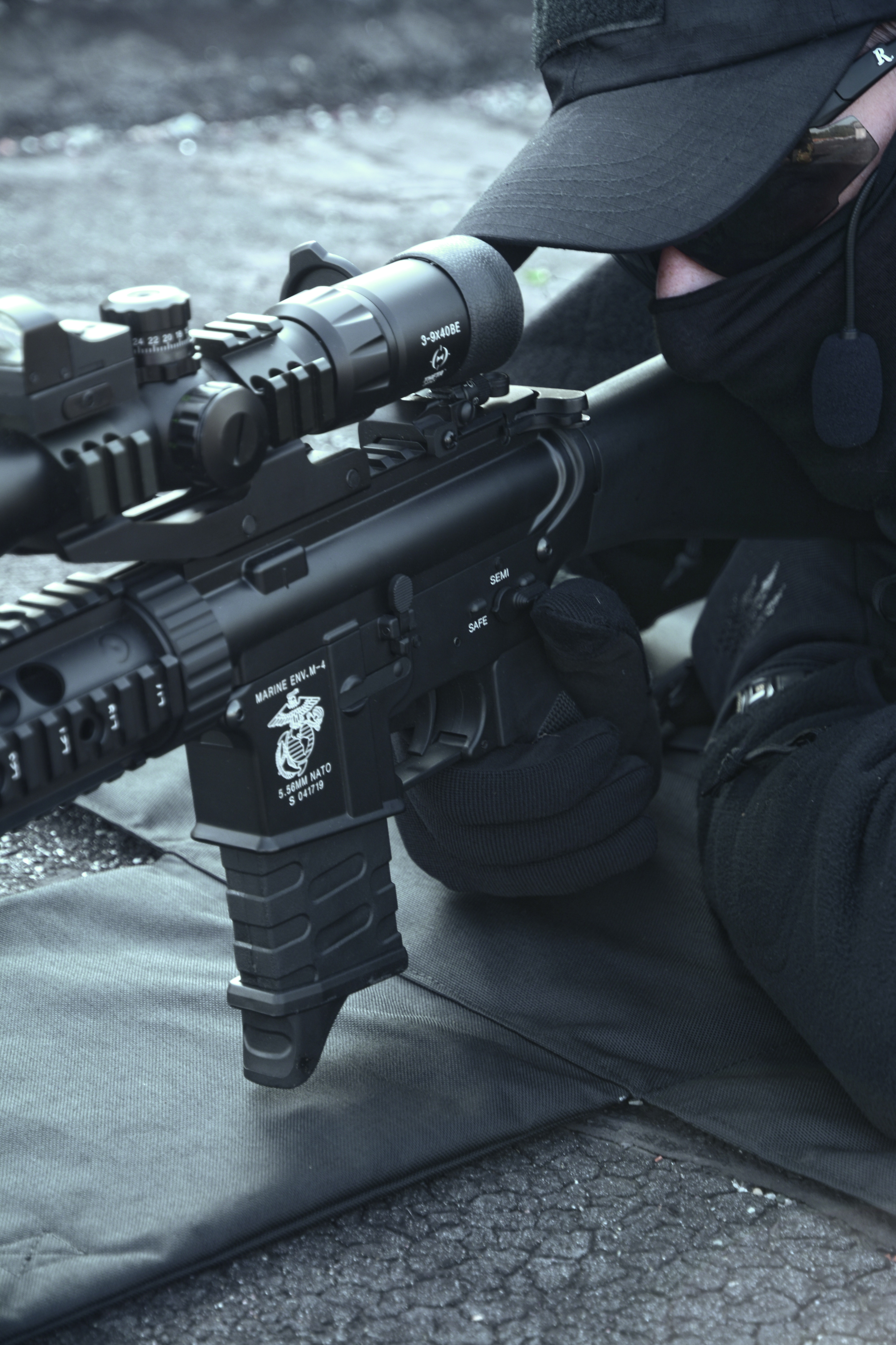 close-up photo of a scope attached to a rifle which a man is holding